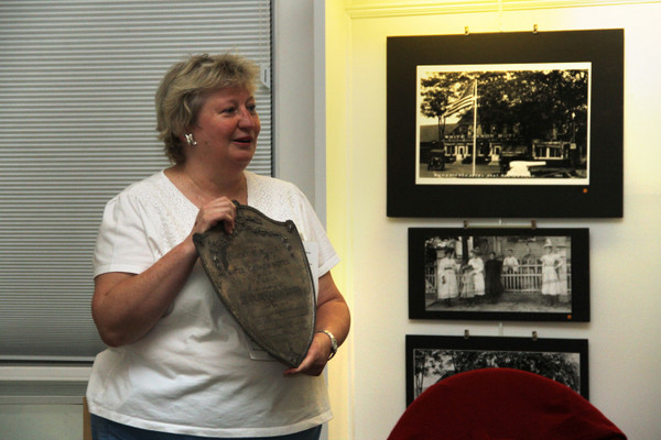 ER Historical Society President Madeline Pearson shows off an artifact of the White Cannon Hotel.