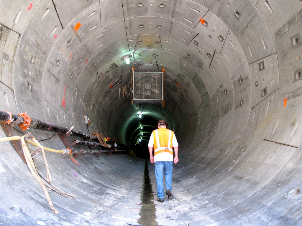 A worker enters a completed tube on the Queens side.