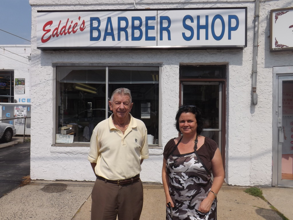 John Lecuit started working at his father’s barbershop in 1954. Anne Moffatt, of Lynbrook, has cut hair there for three years.