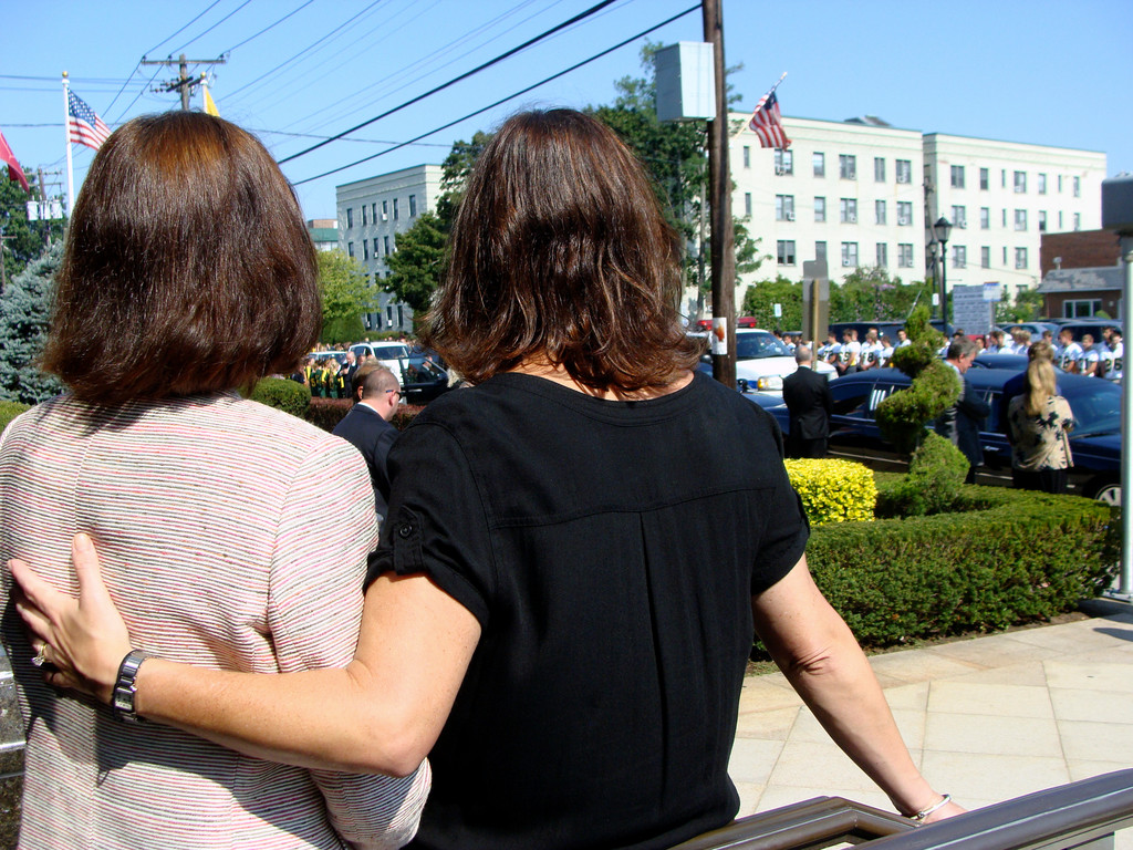 Melissa Burak, the Lynbrook school district’s assistant superintedent for business, left, and school board Vice President Ellen Marcus consoled each other as the hearse pulled up to St. Raymond’s in East Rockaway before the Mass of Christian Burial.
