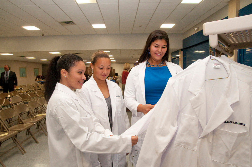 Sileny Urena, left, Fe Ueno and Stacy Lugo, admired the lab coats their fellow BHS students will use for years. The Medical Academy now has 100 students.