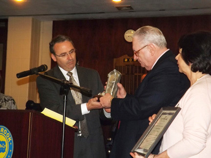 Lyn gift shop owner Bill Gaylor, center, with his son, William Gaylor III, and his wife, Lillian, accepted an award from the Village of Lynbrook.