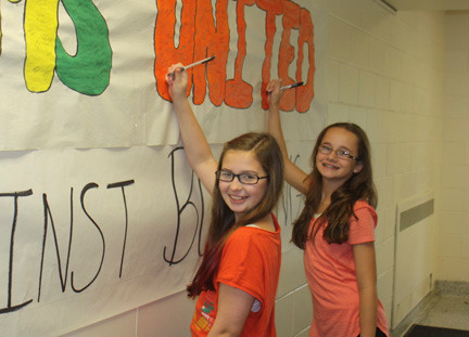 In honor of Unity Day, Lynbrook North Middle School students Graceanne Yadanza (left) and Katie Lenz signed their names to a schoolwide pledge to stand up against bullying.