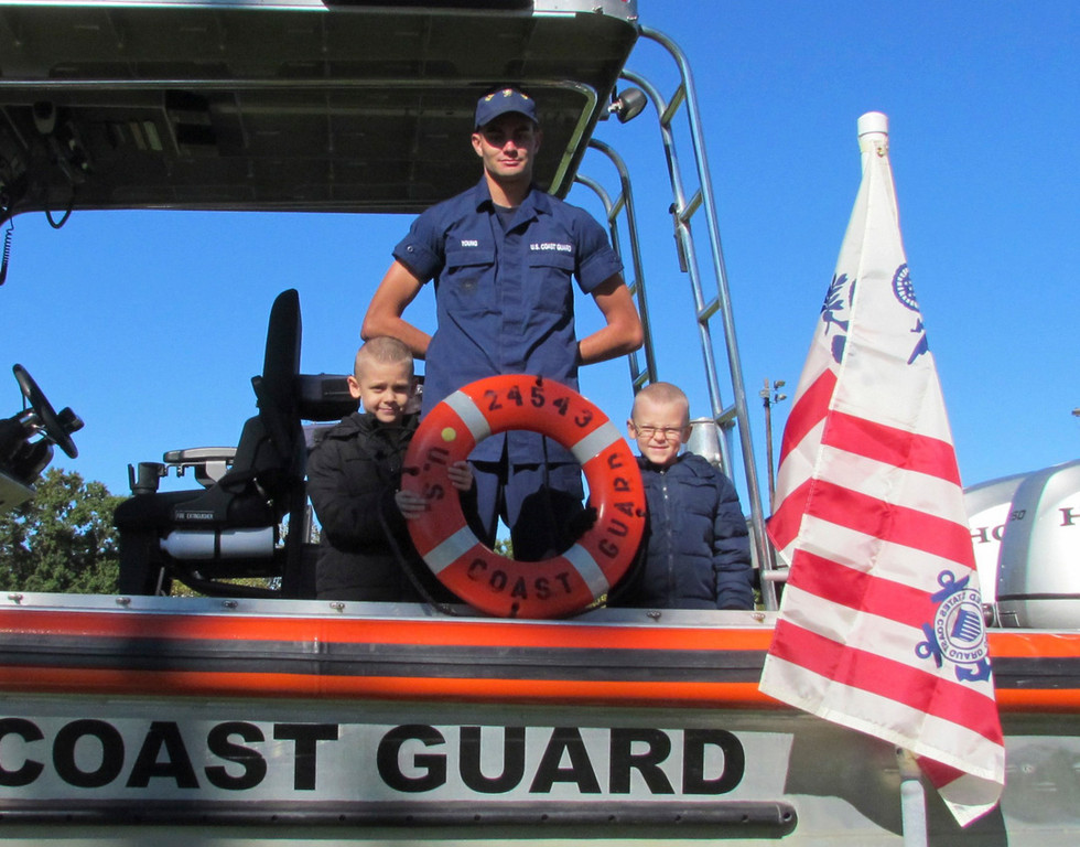 On guard
Fireman David Young of the U.S. Coast Guard stood at the helm of his boat with visitors Jared Cross, 4, left, and his brother, Jacob, 6, at the Lynbrook Expo in Greis Park last Saturday.