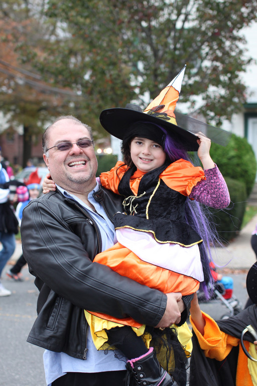 Brianna Rolon, 7, in costume as a witch, with her father, JR, during the parade.