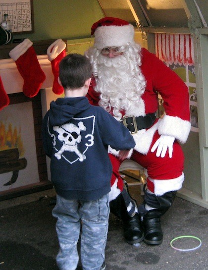 A boy gives santa his Christmas wish list.