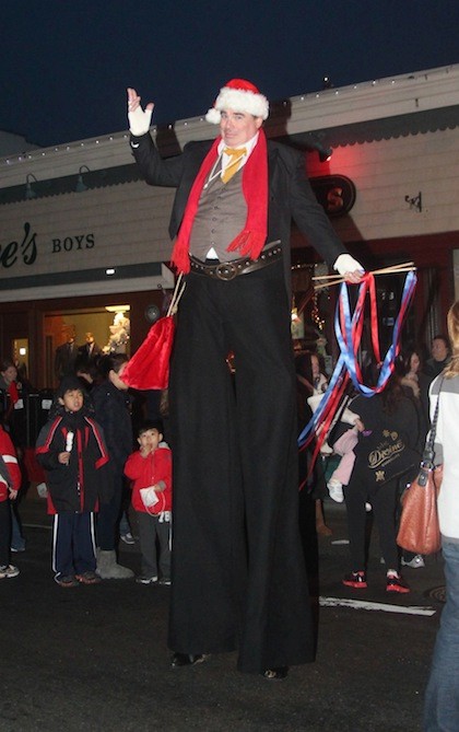 A man on stilts from Clown Magic party Entertainment rose head and shoulders above the crowd.