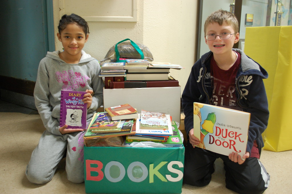 Wheeler Avenue students Isabella Chungata and Michael Ott show some of the books that have been collected to give to schools damaged by Hurricane Sandy.