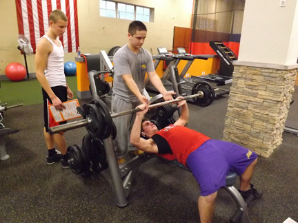 Connor Parzych, a junior at East Rockaway High School, hit the bench press at ROK, spotted by junior A.J. Evans.