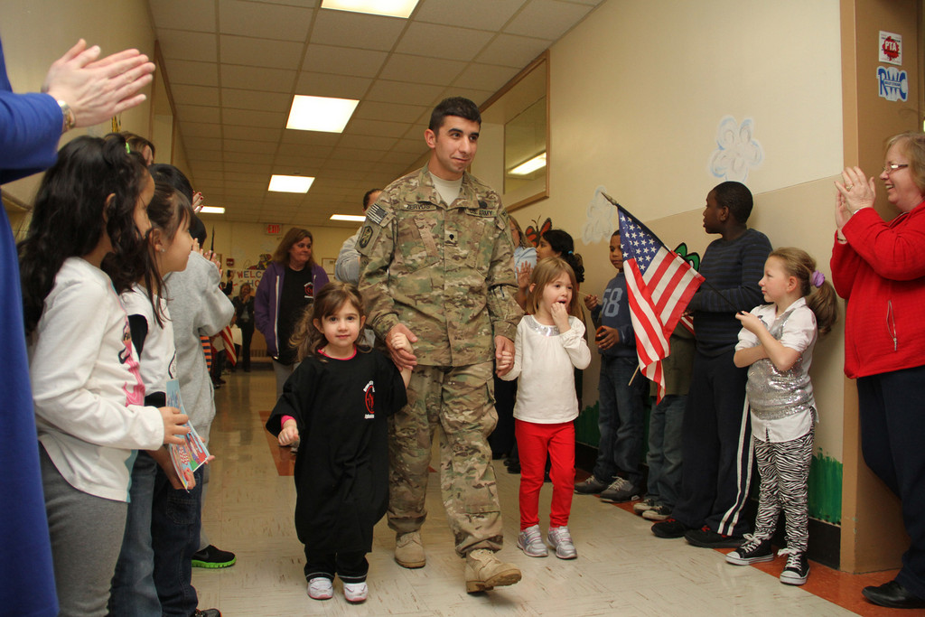 Spc. Michael Zervos, flanked by his daughters Alexandra and Danielle, walked down the hallway while the entire school saluted and applauded him.