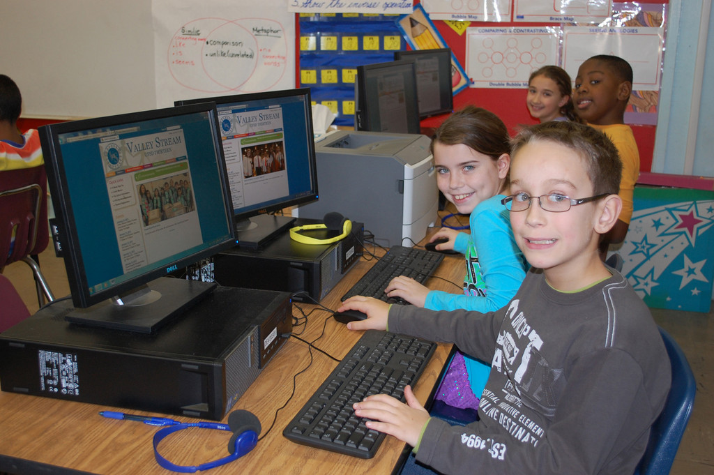 James A. Dever School students, from left, Lucas Almeida, Hailey Danna, Ralph Destin and Jenna Campo use the new District 13 website.