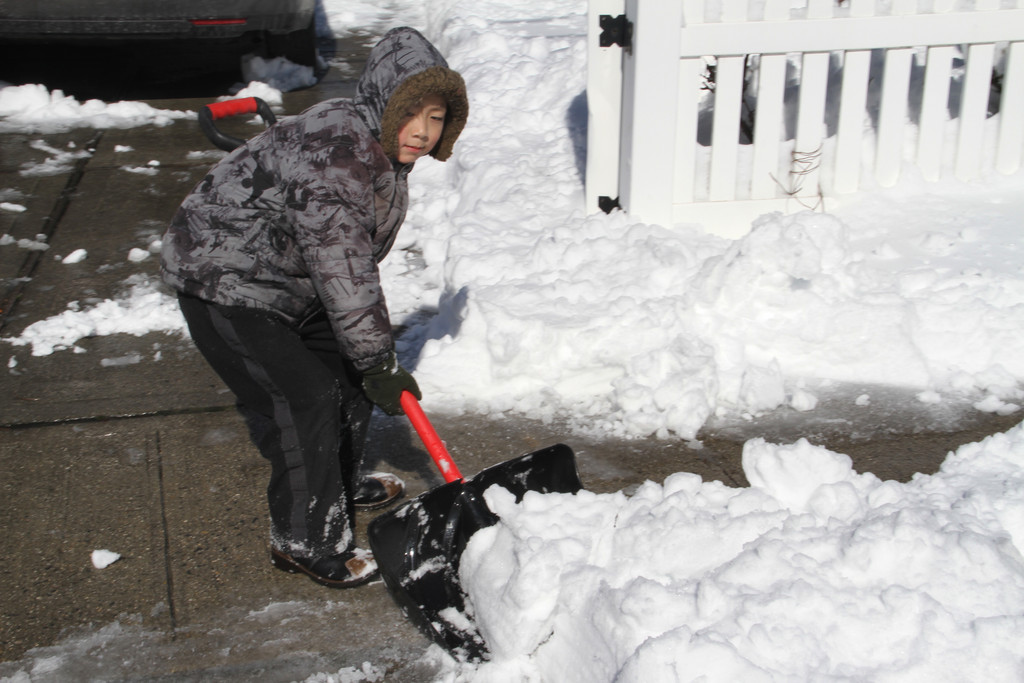Jimmy You lends his dad a hand by shoveling their walkway.