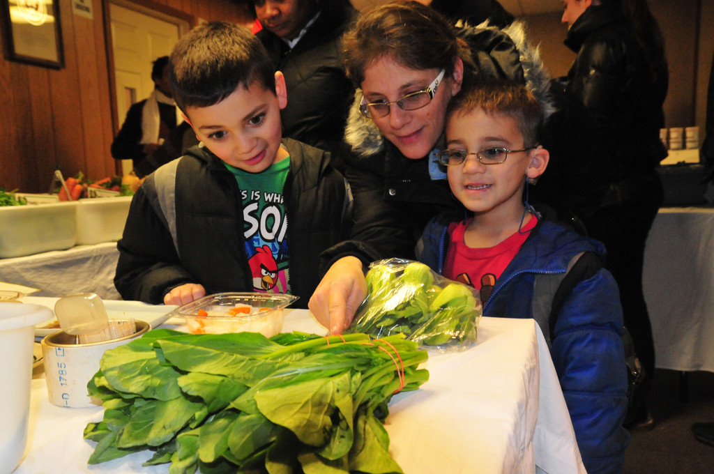 Brendan and Hunter Artzt, 6 and 8, and their mom, Debbie, eyed some spinach at the first Baldwin winter farmers market.