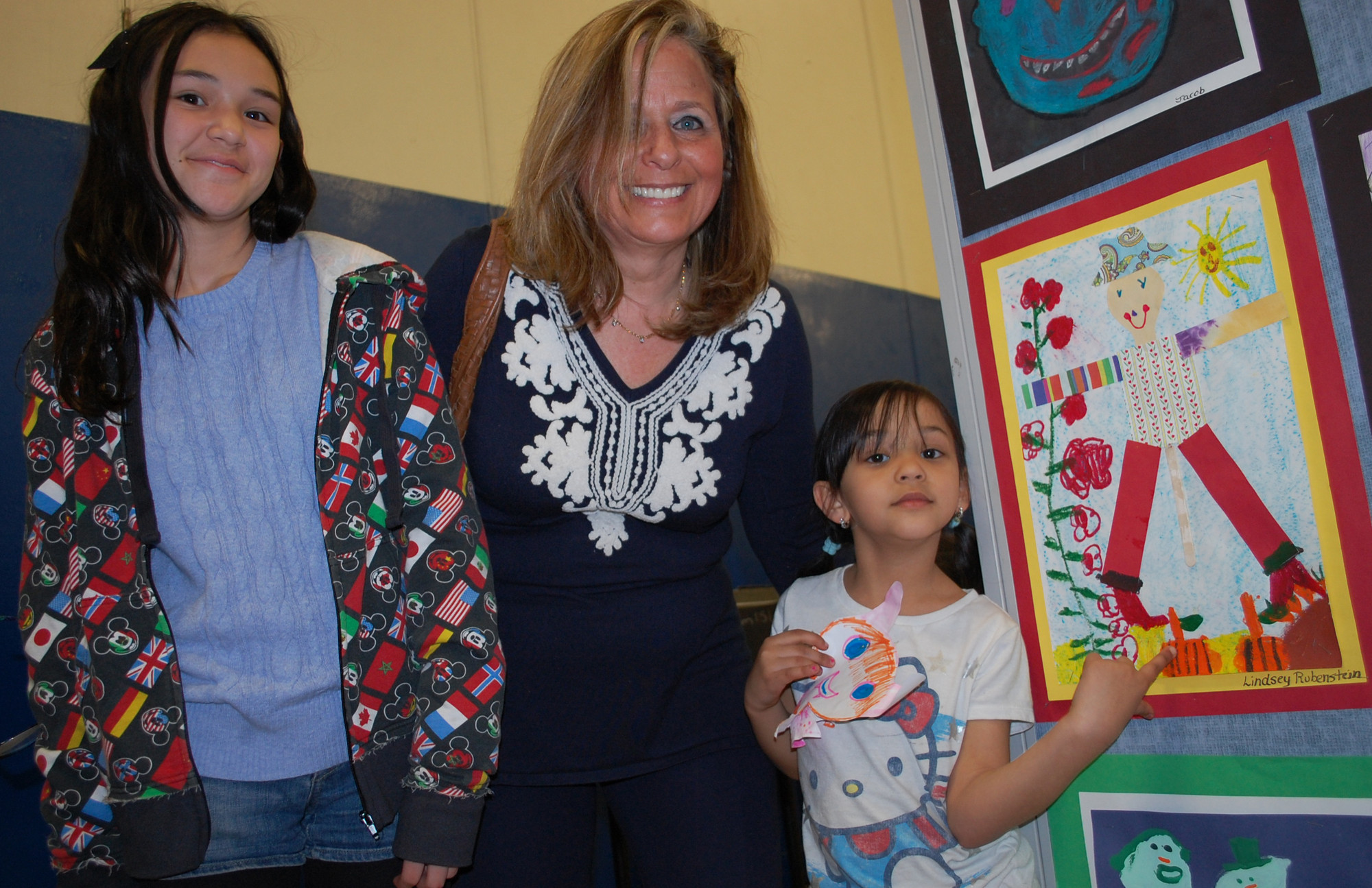 Lindsey Rubenstein, right, a first-grader at Brooklyn Avenue School, joined by her sister Denise and art teacher Jane Berzner, shows her piece in the District 24 art show.