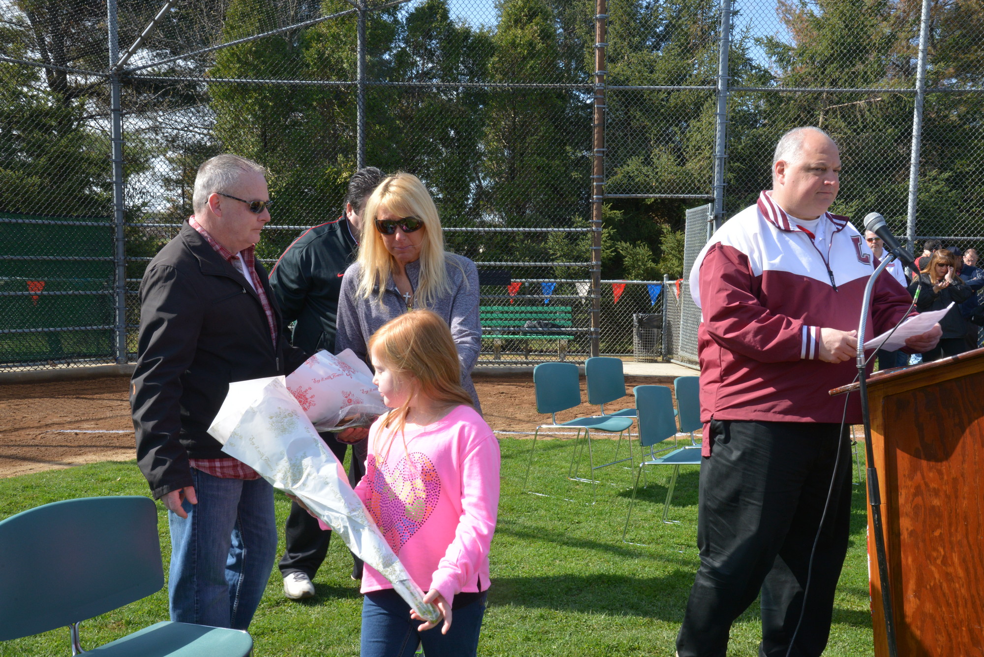 The family of Harlie Treanor, father Kevin, mother Joy Ambrosio and sister Maddie, with league president Joe Aloi during the Central Nassau Little League Parade, which was dedicated to Harlie.