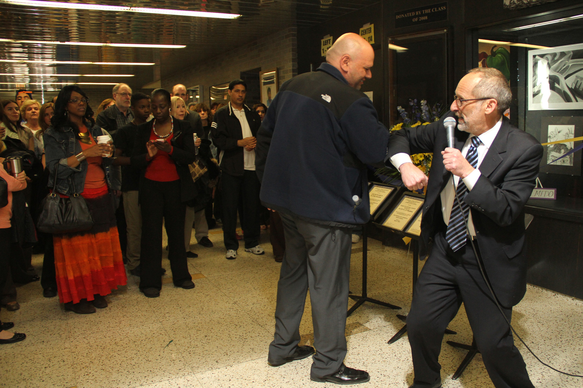 Gary Schall greets Facilities Director Chris Milano with an elbow bump at the ribbon-cutting.