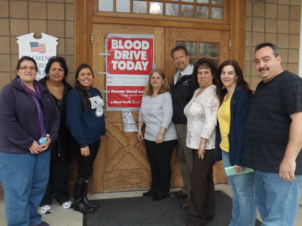 A blood drive was held on April 29 in support of longtime village employee Phil Tondi, who was in a coma for three weeks beginning in February. Pictured outside the blood drive were Tondi’s wife, Barbara, center, Mayor Ed Fare, fourth from right, members of Tondi’s family and his village co-workers.