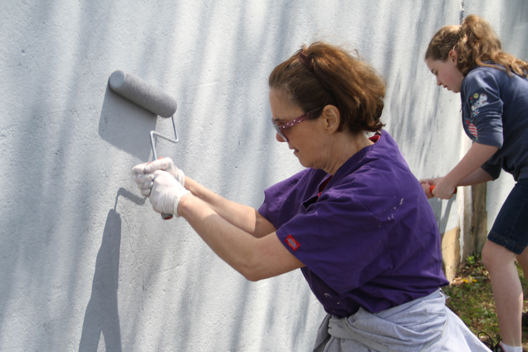 Debbie Laskin and Erin Laxton were among the many volunteers from Envision Valley Stream who painted the Long Island Rail Road trestle wall on April 28.