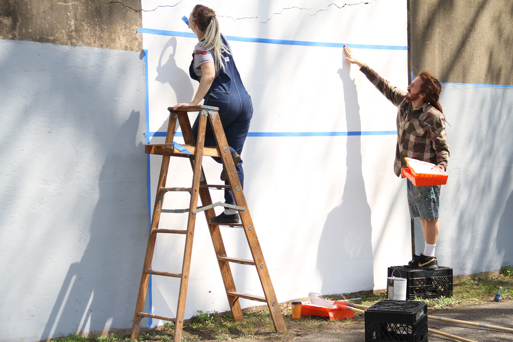 Artists Brittany Ruhnke and Christopher Berger prepared the trestle wall for the mural.