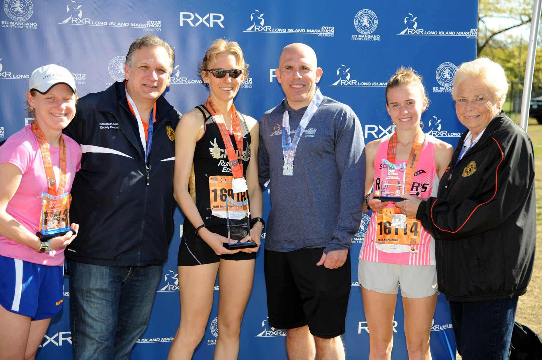 County Executive Ed Mangano, second from left, and Scott Rechler, CEO of RXR realty, the race’s title sponsor, with the women’s top three half marathon finishers, first-place Jodie Robertson, third from left, second-place Stefanie Braun, second from right, and third-place Lindsey Block, far left. Also pictured is County Legislator Rose Walker.