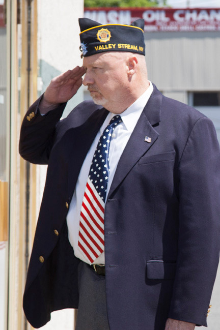 John Faust, commander of American Legion Post 854, salutes during the memorial service.