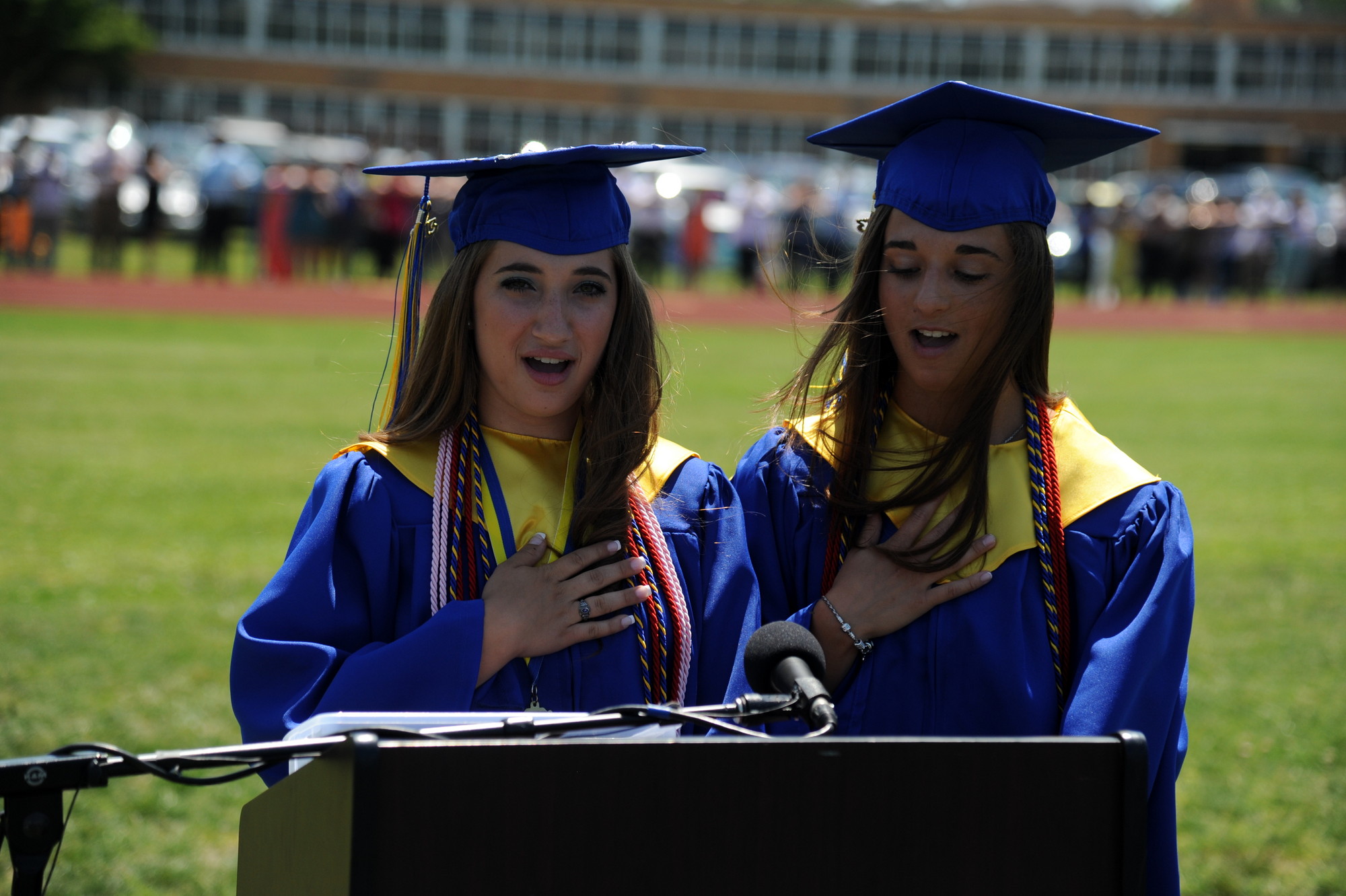 Carly Salzman,
left, and Jaclyn Tortora led the hundreds in attendance in reciting the Pledge of Allegiance.