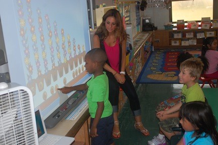 Jessica Correale, a volunteer with the District 24 summer school and an aspiring teacher, helps kindergarten students with their math skills.