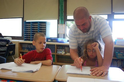 Teacher John Reece reviews times tables with students in his class.