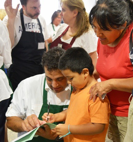 NEIL SKLAR helped Danilo Bustillo check off the school supplies he needs as mom Romula Cuba watched.