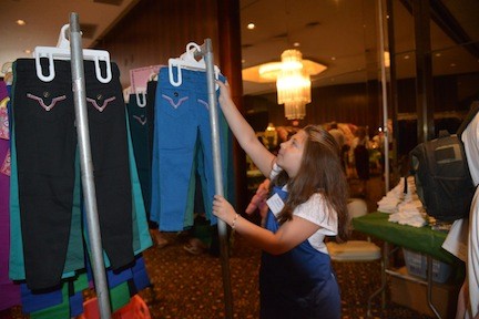 junior volunteer Emily Rosenblum, 9, helped organize pants at the back to school store.