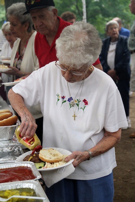 Food was aplenty during the picnic, as Frances Catalfomo added mustard to her burger.