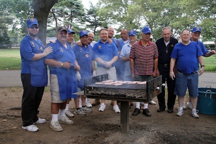 The Knights of Columbus surrounded the grill during its annual picnic at Eisenhower Park on Saturday.