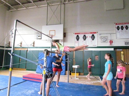 Students practiced the uneven bars during gymnastics class.