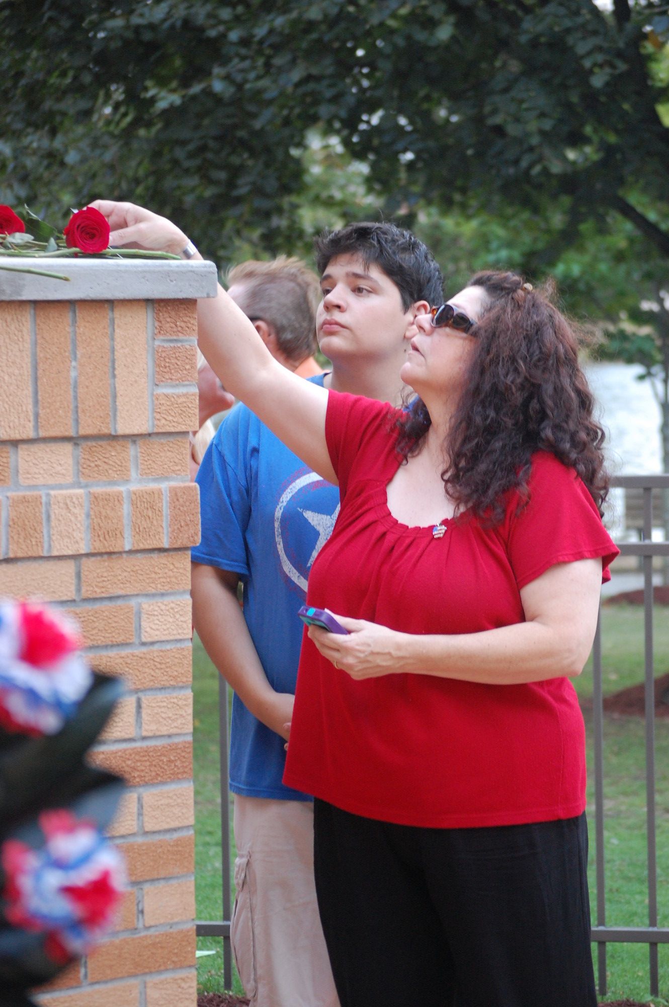 Mourners placed carnations on the monument at Hendrickson Park.