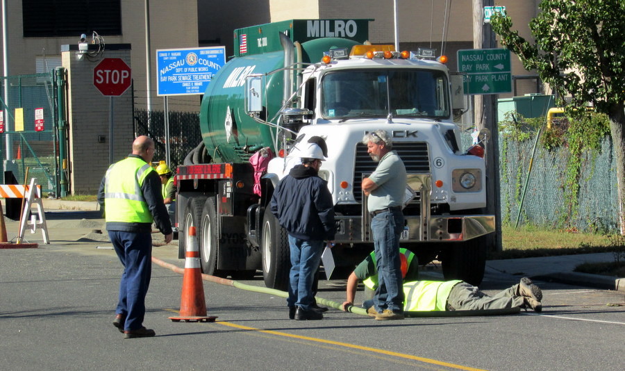 Workers clean up oil that accidentally spilled from a truck during a Wednesday morning delivery to the plant.