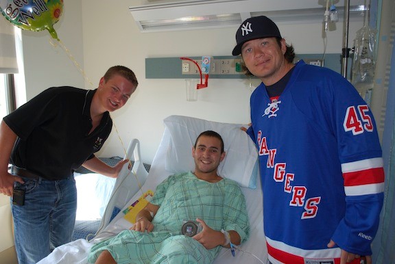 Ray Mohler, left, and New York Rangers superstar Arron Asham delivered smiles and an autographed hockey puck to a hospitalized youth.