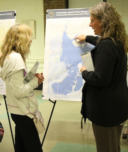 Jennifer Street, right, with a map of Oceanside, Island Park, Harbor Isle and Barnum Island, discussed various options for rebuilding the area and making it more sustainable with resident Ellen McDermott.