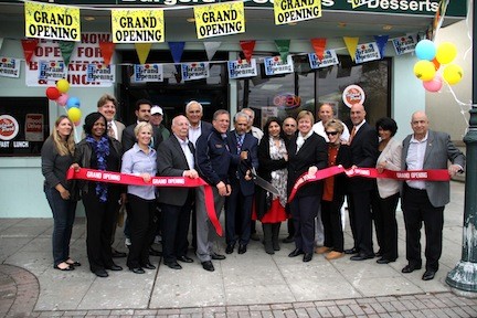 Owners Sha Shi, Roger and TJ Gutral with VIPs and Chamber of Commerce members cut the ribbon at the grand opening of the new Island Park Deli.