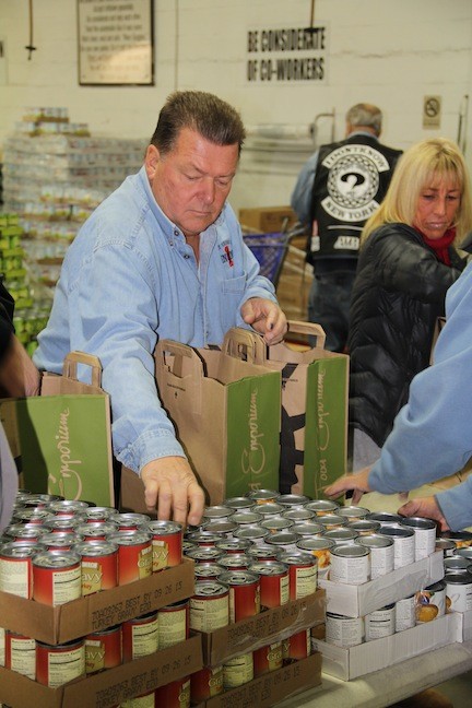 John Danz, a firefighter in Bay Shore, volunteered his time to help fill bags of food for distribution.