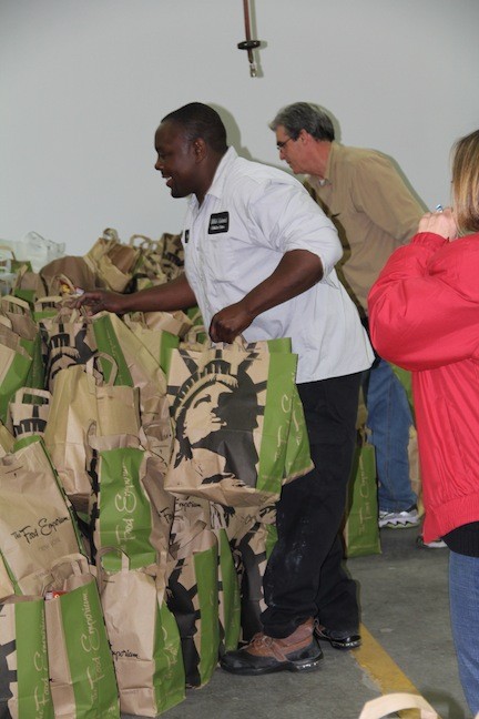 Leighton Murray, an employee at Mid-Island Collision, helped stack up the bags full of food.