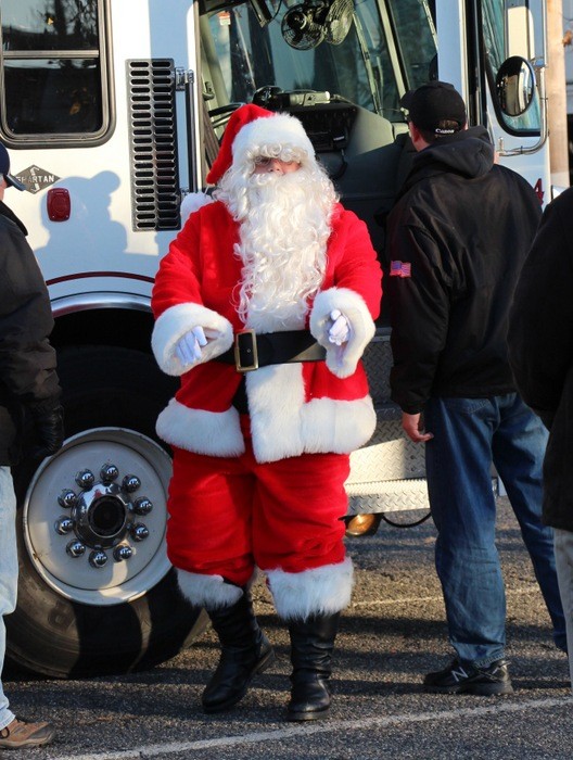 Santa is making a delievery of good cheer to the kids of Lynbrook. He is stepping out of the Lynbrook Firetruck.
