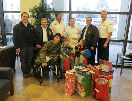Courtesy Steve Grogan
Lynbrook firefighters and others traveled to Bethesda, Md., last week to hand out gifts and cards to military servicemen and their families. In front were U.S. Marine Cpl. Marcus Dandrea with his sons Micah and DJ, seated on Santa’s lap. Standing, from left, were Lynbrook Village Trustee Hilary Becker, Honorary Chief Larry Meyers, former Capt. Richard Straub, firefighter Chris Hynes, former Chief Kevin Bien and former Capt. Steve Grogan.
