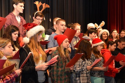 The chorus sings Christmas carols.