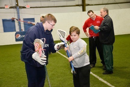 Danny Marshall helps Michael Hagan at the special needs lacrosse clinic held at Turf Island indoor sports facility in Oceanside.
