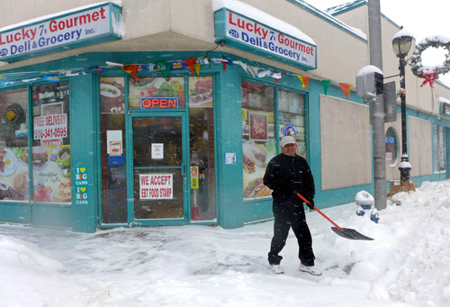 Clearing the sidewalk in front of Lucky 7s Gourmet on the corner of Atlantic and Centre avenues in East Rockaway.