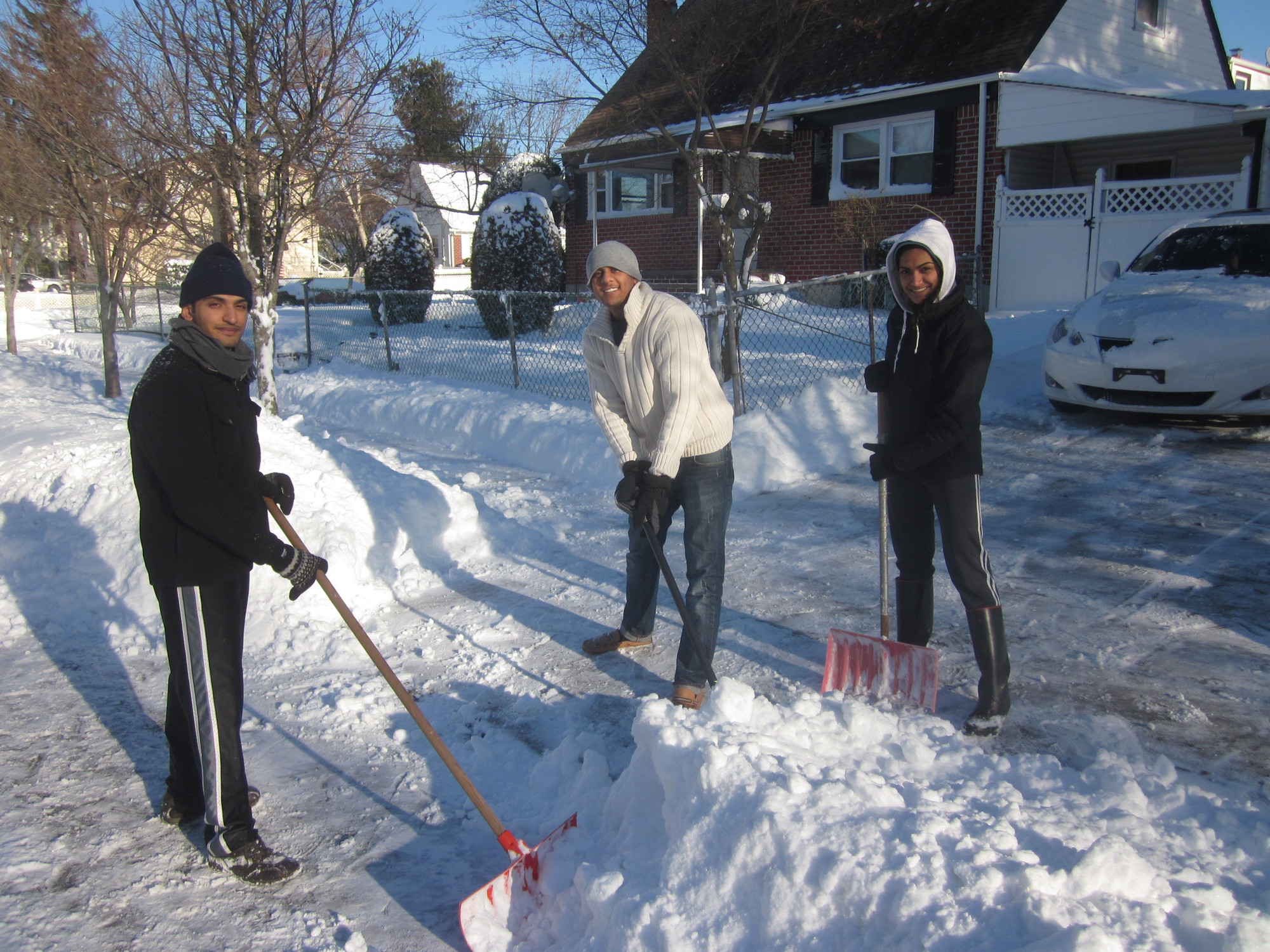 The Patels, from left, Ajay, Dave and Nilam made shoveling a family activity in front of their Lincoln Avenue home.