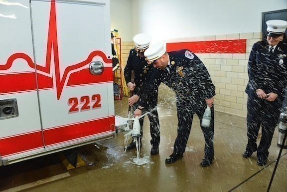 Former chief and current Captain Fran Eye, left, and Chief Anthony D’Esposito broke a champagne bottle to officially welcome the department’s new ambulance last Sunday, as Lieutenant Margaret Rodriguez looked on.
