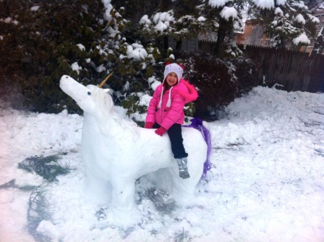 Mchala Klimowicz rides a snow unicorn build by Christopher and Melissa Klimowicz.
