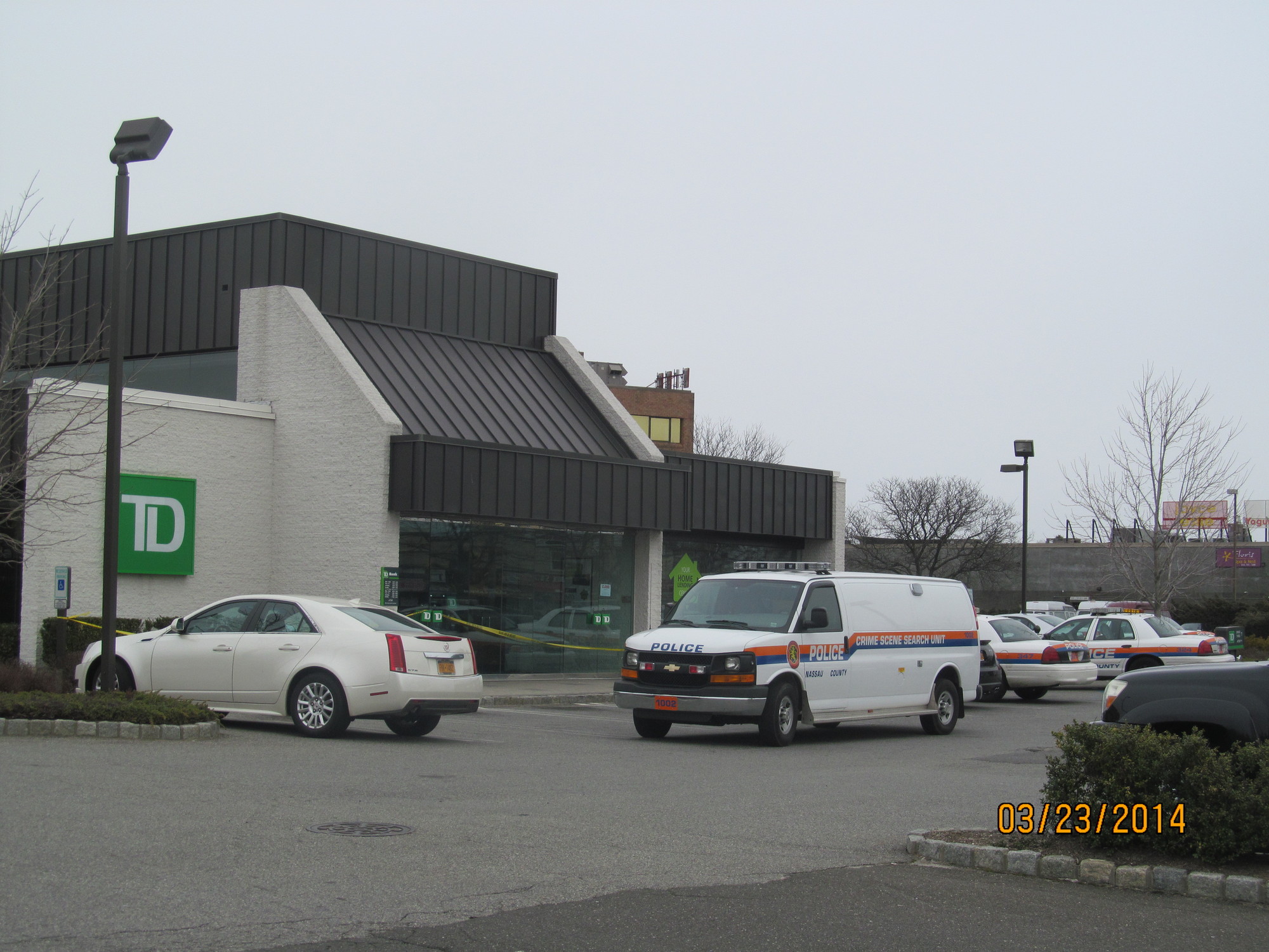 After robbing TD Bank Sunday, police say a woman fled in a “dark colored” car.