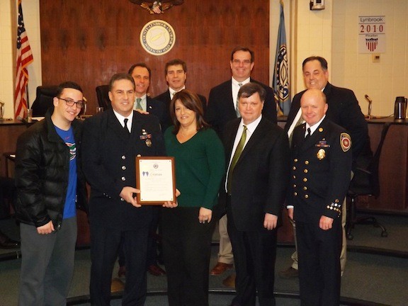Lynbrook firefighter Michael Kenny saved the life of a 2-year-old aboard a flight to El Salvador in January. He was recognized by the Village of Lynbrook last month for his actions. He was accompanied by his son, Tyler, and his wife, Lisa. He was joined by Lynbrook Mayor William Hendrick, FD Chief Ed Hynes, front row; back from from left Trustee HIlary Becker, Dep. Mayor Alan Beach, and Trustees Tom Aktinson and Mike Hawxhurst.